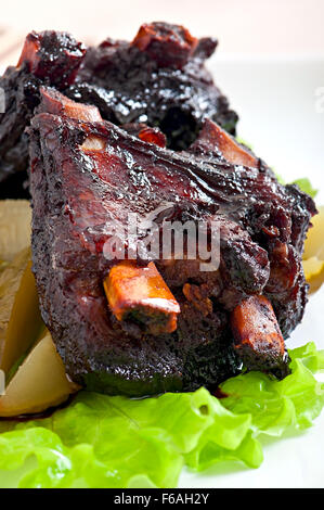 Gebackenes Rindfleisch Rippen in Honig-Soja-Marinade mit eingelegtem Gemüse Stockfoto