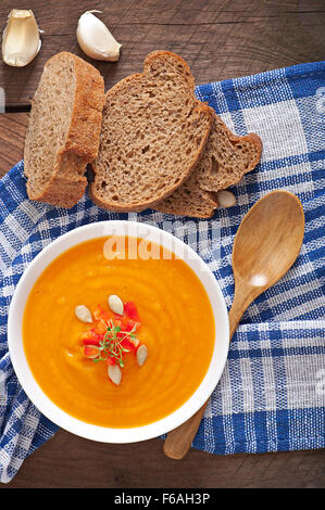 Lecker Sahne Kürbis Suppe in eine Schüssel auf Holztisch Stockfoto