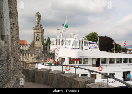 Lindau, Deutschland - Vergnügen Touristenboot vorbei an bayerischen Löwe Skulptur und Leuchtturm, Eintritt in Lindau Hafen Hafen Stockfoto