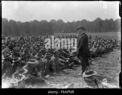 Premierminister William Massey aus Neuseeland spricht während eines Besuchs an eine Gruppe von Maschinenschützen, die wahrscheinlich mit Militärdienst oder Kriegsanstrengungen während seiner Amtszeit zusammenhängen. Dieses Foto zeigt einen Moment der neuseeländischen Führung und militärischen Beteiligung. Stockfoto