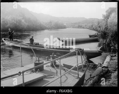Ein historisches Foto, das eine Flusslandung auf dem Whanganui River in der Nähe von Taumarunui, Neuseeland, aufnimmt. Das Bild zeigt die Rolle des Flusses als wichtige Transportroute in der Region. Stockfoto