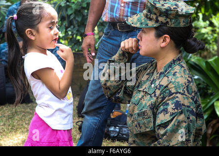 Leutnant Oberst Maisie Wong, zivile Angelegenheiten Spezialist aus 4. Civil Affairs Group, zeigt ihr Zähneputzen zu einem lokalen honduranischen Kind bei Manos Chicas, Corazon Grande Schule in Trujillo, Honduras, während eine Gemeinschaft-Relations-Veranstaltung Betrieb weiterhin Versprechen am 4. September 2015 zu unterstützen. Betrieb weiterhin Versprechen ist eine Mission, in denen das US-Militär mit Gastländern arbeitet, humanitäre Hilfe und führen Sie zivil-militärische Operationen neben verschiedenen Partnerstaaten in der Karibik und zentral- und Südamerika. (U.S. Marine Corps Foto von CPL. Kirstin M Stockfoto