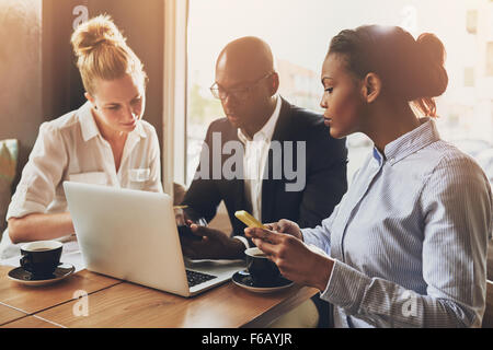 Multi-ethnische Unternehmer Planung ihrer Arbeit mit Laptop und Handy Stockfoto