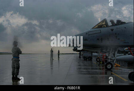 US Air Force Crew Häuptlinge aus der 354. Expeditionary Jagdstaffel darauf vorbereiten, US Air Force a-10 Thunderbolt II Kampfflugzeuge auf dem Taxi Weg während einer Theater-Security-Paket-Bereitstellung zu Lask Air Base, Polen, 9. Juli 2015 zu marshallen. Die a-10 unterstützt US Air Force Missionen auf der ganzen Welt im Rahmen seiner aktuellen Bestandsaufnahme der Streik Plattformen, einschließlich f-15 Eagle und f-16 Fighting Falcon Kampfflugzeuge als Bestandteil der TL (US Air Force Foto von Staff Sgt. Christopher Ruano/freigegeben) Stockfoto