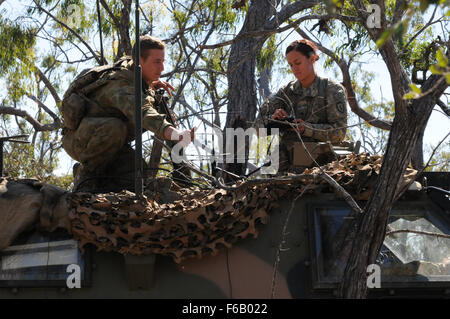 Ein US-Soldaten zugewiesen der 2. 27. Field Regiment, Bataillon, 25. Infanterie-Division, 3. Brigade Combat Team und Mitglied der australischen 7. Brigade richten Sie eine Satelliten-Antenne während der Übung Talisman Saber 2015 auf Shoalwater Bay Truppenübungsplatz in Queensland, Australien, 14. Juli 2015. Talisman Saber ist eine kombinierte Biennale Übung zwischen der USA und Australiens Streitkräfte entworfen, um beide Nationen Fähigkeit zur Reaktion auf regionalen Eventualitäten zu verbessern. (US Armee-Foto von Sgt. Brian C. Erickson/freigegeben) Stockfoto