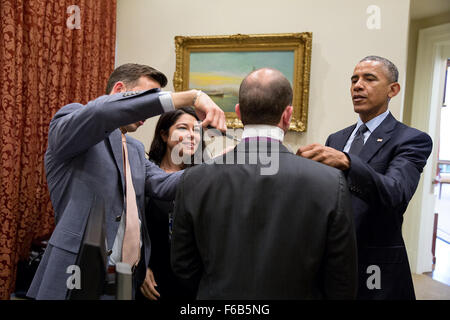 Präsident Barack Obama, Brian Mosteller, Director des Oval Office Operations und persönlicher Adjutant Ferial Govashiri helfen Ben Rhodes, stellvertretender nationaler Sicherheitsberater für strategische Kommunikation mit seiner Krawatte im äußeren Oval Office, 17. April 2015. Stockfoto