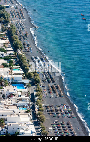 Santorini Thira. Luftaufnahme von Kamari Resort Stadt mit Reihen von Sonne Liegen und Sonnenschirme am Strand, und vor allem weiß cubiform Gebäude in der Stadt. Stockfoto