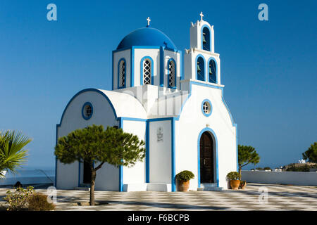 Kykladen, Santorin, Thira. Die kleinen traditionellen blau-weißen Orthodoxen griechischen Kirche mit blauer Kuppel und Glockenturm. Gegen den klaren blauen Himmel. Stockfoto