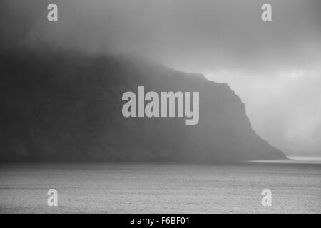 Isländische Fjord mit Nebel schwarz und weiß Stockfoto