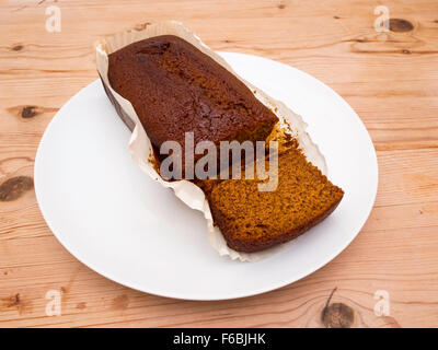 Yorkshire Parkin oder Perkin machte einen traditionellen Kuchen mit Sirup Haferflocken und Ingwer weiße Platte Holztisch mit einem Slice-Schnitt Stockfoto