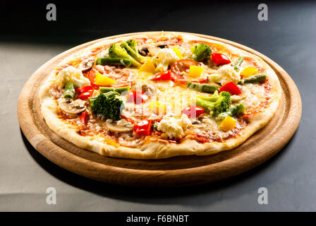 vegetarische Pizza auf einem dunklen Hintergrund mit Champignons, Käse und Paprika Stockfoto