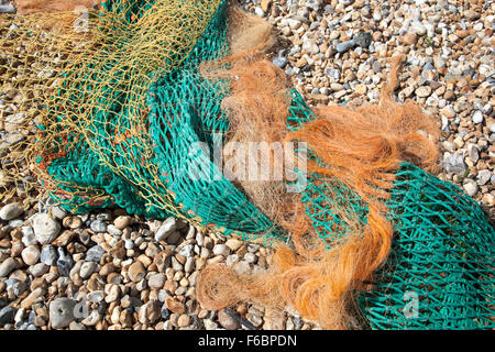 Verworrenen, bunten Fischernetze auf einem Kiesstrand Stockfoto