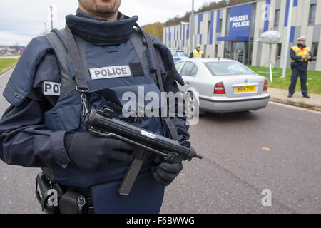 Saarbrücken, Deutschland. 15. November 2015. Eine bewaffnete französische Polizist sichert den Kontrollpunkt am Grenzübergang Goldene Bremm wo Deutsche und französische Offiziere Autos kontrollieren, nach der Ankunft aus Frankreich in Saarbrücken, Deutschland, 15. November 2015. Mindestens starben 129 in einer Reihe von Terroranschlägen in Paris. Foto: OLIVER DIETZE/Dpa/Alamy Live News Stockfoto