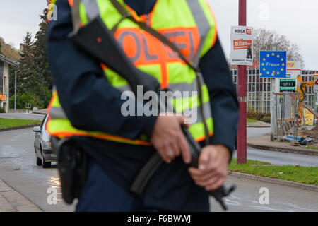 Saarbrücken, Deutschland. 15. November 2015. Ein deutscher Polizist mit einem Maschinengewehr bewaffnet steht an der Metzer Straße wo Autos inspiziert werden, nach der Ankunft aus Frankreich in Saarbrücken, Deutschland, 15. November 2015. Mindestens starben 129 in einer Reihe von Terroranschlägen in Paris. Foto: OLIVER DIETZE/Dpa/Alamy Live News Stockfoto