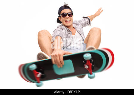 Junge männliche Skater Kunststücke mit seinem Skateboard erschossen in der Luft isoliert auf weißem Hintergrund Stockfoto