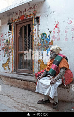 Sadhu draußen Tempel mit bemalten Wand, Nathdwara, Rajasthan, Indien, Asien Stockfoto