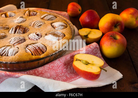 Apple Pie in eine Auflaufform, Leinen-Serviette und Äpfel auf dunklem Hintergrund, selektiven Fokus Stockfoto