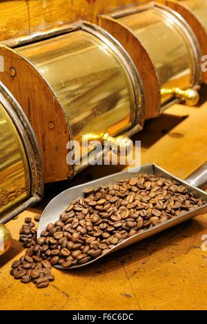 Kaffee-Schaufel mit Kaffeebohnen vor einem Kaffee-container Stockfoto
