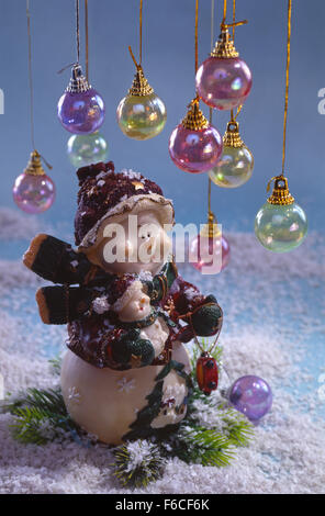 Festliches Silvester, Weihnachten Stilleben - zwei fantastische Spielzeug-Schneemänner auf Schnee mit bunten Weihnachtskugeln Stockfoto