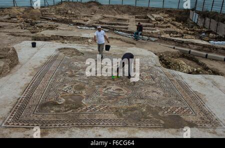 (151116)--LOD (ISRAEL), 16. November 2015 (Xinhua)--Arbeiter Aufräumen ein Patch der 1.700 Jahre alte Mosaik in Lod, einer Stadt östlich von Tel Aviv in Zentral-Israel am 16. November 2015. Israel Antiquities Authority enthüllt Montag ein römischer Zeit Bodenmosaik, die ausgegraben letztes Jahr während Konstruktionen ein Besucherzentrum wurde, ein weiteres Mosaik entdeckt vor zwei Jahrzehnten an der gleichen Stelle aufweisen soll. Archäologen zufolge "atemberaubende" Mosaik als eine Etage einer Villa Wohnzimmer ca. 1.700 Jahren diente. (Xinhua/Li Rui) Stockfoto