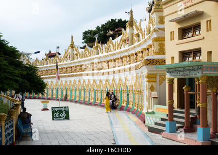 SAGAING, Myanmar – die OoHminThoneSel Pagode, hoch auf einem Hügel in Sagaing, verfügt über eine lange, geschwungene Nische, die mit Dutzenden von Statuen des Buddha gesäumt ist. Nach kürzlich stattfindenden Renovierungen und Modernisierungen, die von Spendern ermöglicht wurden, ist die Pagode mit farbenfrohen Fliesenmosaiken und frischen, hellen Farben verziert. Stockfoto