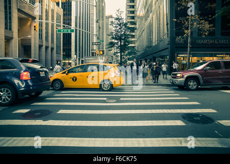 Hier abgebildet ist eine Straßenansicht in Midtown Manhattan mit Autos, Taxis und Menschen sichtbar. Stockfoto