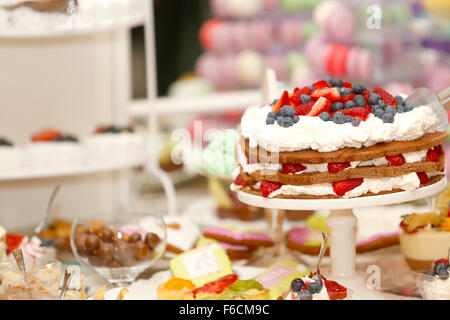 Köstliche Keks-Kuchen mit Erdbeeren und Heidelbeeren auf süße Tisch für Hochzeitsfeier Stockfoto