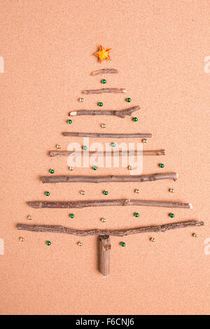 Weihnachtsbaum aus Stöcken auf Holz Hintergrund angeordnet Stockfoto