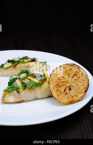 Stück gebackener Fisch Barsch mit Kräutern und Zitronenscheiben Stockfoto