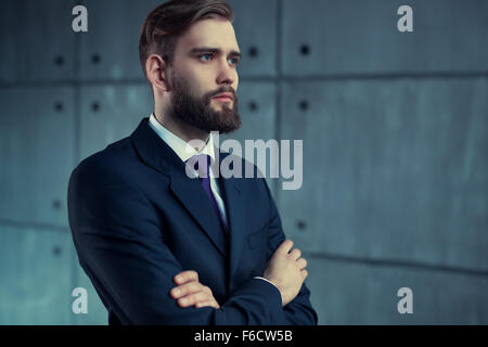 Schönen jungen Mann mit Bart im schwarzen Anzug auf der Suche zur Seite. Stockfoto