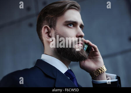 Gut aussehend Jungunternehmer mit Bart am Telefon Porträt sprechen. Stockfoto
