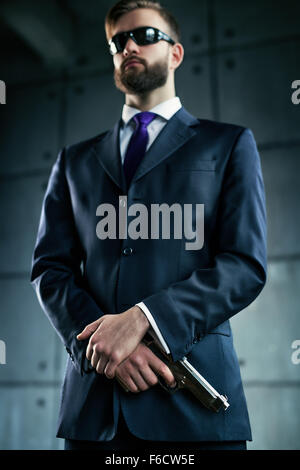 Gefahr Mann Agent mit Pistole und Sonnenbrillen. Konzentrieren Sie sich auf Hände und Pistole. Stockfoto