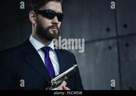 Gefahr Mann mit Gewehr und Sonnenbrille Porträt Agent. Stockfoto