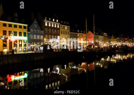 Ein Weihnachtsfest dekoriert und beleuchtet Nyhavn spiegelt sich in der ruhigen Nyhavn Kanal an einem kühlen und dunklen Novemberabend. Stockfoto