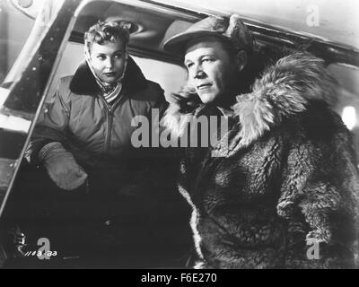 Datum der Freigabe: 19. Oktober 1952. FILMTITEL: Arktische Flug. STUDIO: Monogram Pictures. PLOT: Mike Wein, ein Alaskan Bush Pilot Betrieb der Bering Seegebiet, freundet sich mit John W. Wetherby, posieren als Reichtum Vereinigten Staaten Geschäftsmann. Aber in Wirklichkeit ist er ein russischer Spion auf dem Weg nach Sibirien tragenden Mikrofilme von den Vereinigten Staaten Verteidigung-Installationen. Im Bild: WAYNE MORRIS als Mike Wein und LOLA ALBRIGHT als Martha Raymond. Stockfoto