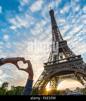 Hände, die Bildung von Herz, Sonnenuntergang hinter Eiffelturm, Champ de Mars, Paris, Ile de France, Frankreich Stockfoto