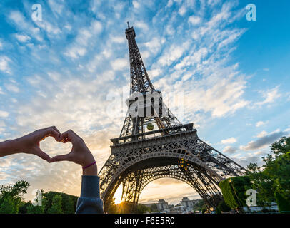 Hände, die Bildung von Herz, Sonnenuntergang hinter Eiffelturm, Paris, Ile de France, Frankreich Stockfoto