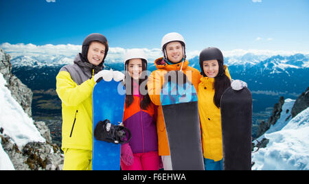 Glückliche Freunde in Helme mit Snowboards im freien Stockfoto