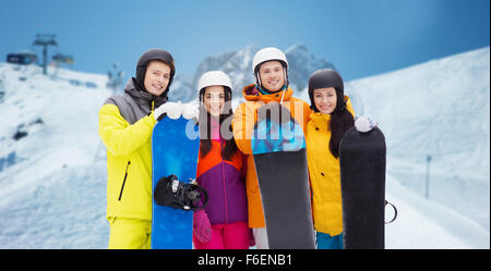 Glückliche Freunde in Helme mit Snowboards im freien Stockfoto