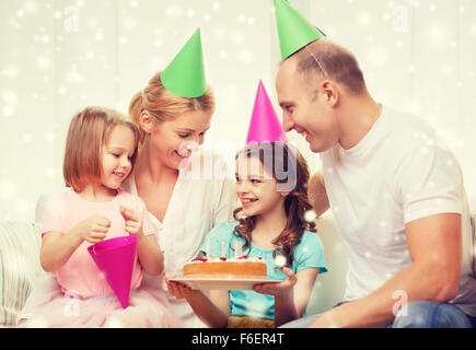 glückliche Familie mit zwei Kindern in Partyhüte zu Hause Stockfoto