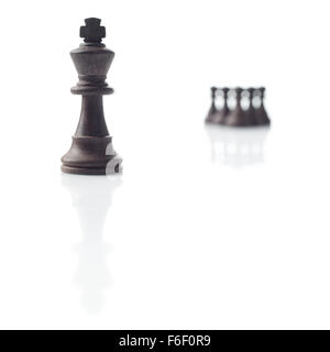 Schach. Schwarzer König, fünf Bauern aus dem Fokus und ihre Schatten auf weißem Hintergrund Stockfoto