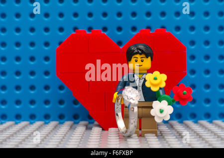 Tambow, Russische Föderation - 3. September 2015 Lego Mann Minifigur mit Ring und Blumen stehen im Vordergrund des Herzens. Stockfoto