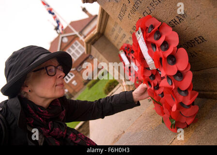 Frau einen Kranz von St John Ambulance am Kriegerdenkmal High Street gelegt, während die 2015 Volkstrauertag Commemoratio Inspektion Stockfoto