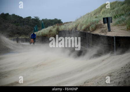 Pembrey Strand, Süd-Wales, UK, Dienstag, 17. November 2015. Trotz Gales Böen bis zu 50 km/h in den südlichsten Teilen von Wales kämpft ein Mann um ein Fahrrad auf dem Weg zum Strand gegen wirbelnden und Flugsand, Pembrey Country Park, in der Nähe von Llanelli, Carmarthenshire, Wales, UK zu schieben. Stockfoto