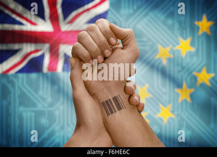 Barcode-ID Nummer Tätowierung am Handgelenk der dunkle enthäutete Person und Nationalflagge auf Hintergrund - Tuvalu Stockfoto