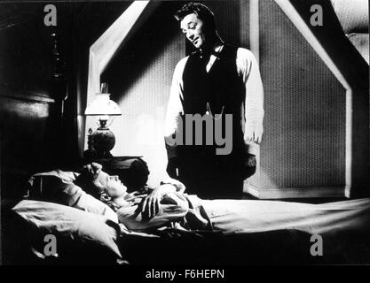 1955, Filmtitel: Nacht des Jägers, Regie: CHARLES LAUGHTON, Studio: UA, im Bild: ROBERT MITCHUM, SHELLEY WINTERS, dunkel, MOODY, gute Nacht, Bett (IN/ON), BEDROHLICH, unberechenbar, psychisch instabil, verrückt, verrückt, PSYCHOTISCHEN, vorsichtig, Lampe, Taille Mantel, religiöse FANANTIC, unsicher. (Bild Kredit: SNAP) Stockfoto