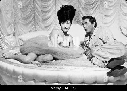 1964, Filmtitel: Was A WAY TO GO, Regisseur: J. LEE THOMPSON, Studio: FOX, abgebildet: SHIRLEY MacLAINE, ROBERT MITCHUM, BOUFFANT, Haar -, rundem Bett, Bett (IN/ON), liegend, flirten, verführen, Romantik, bestaunen, bewundern. (Bild Kredit: SNAP) Stockfoto