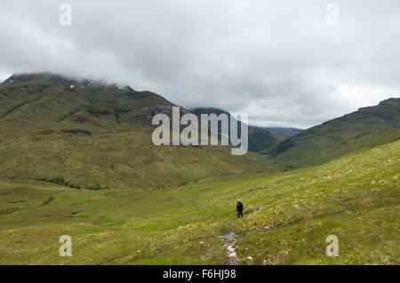 Eine einsame weibliche Walker stapft von Glen Nevis auf der Piste in der Nähe von Sgurr ein bhuic Stockfoto