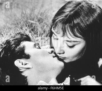 1959, Filmtitel: GREEN MANSIONS, Regie: MEL FERRER, Studio: MGM, abgebildet: AUDREY HEPBURN, ANTHONY PERKINS, Romantik, küssen, liegen, liegen, Rasen, Feld, PADDOCK. (Bild Kredit: SNAP) Stockfoto