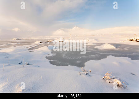 Eine dicke Schneedecke am Ufer des man Na Stainge, Rannoch Moor, Schottland, kurz nach Sonnenaufgang gesehen Stockfoto